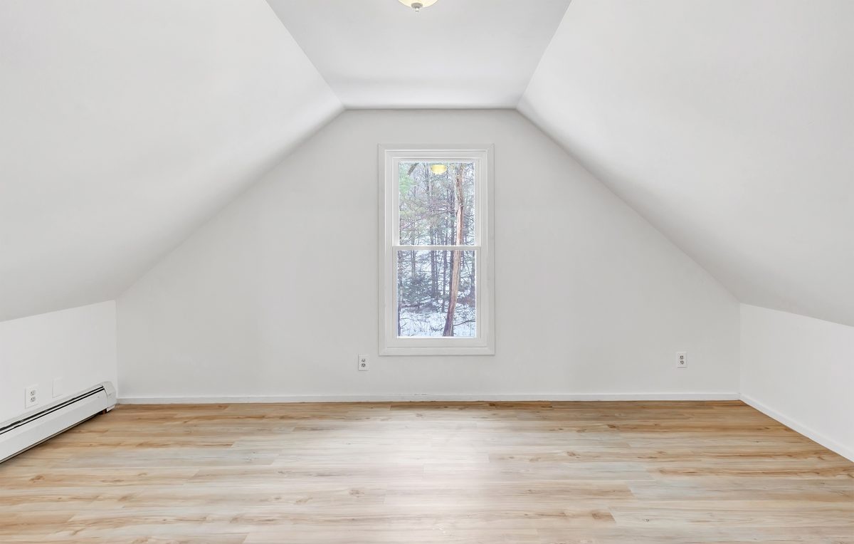 Empty upstairs bedroom with sloped ceiling