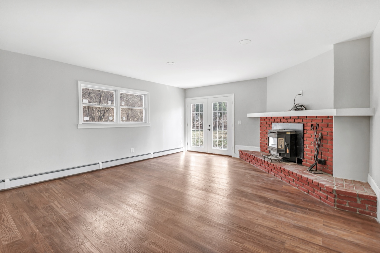 Empty New Milford CT first-floor den with fireplace before virtual staging